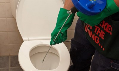 Plombier débouche un WC avec un furet
