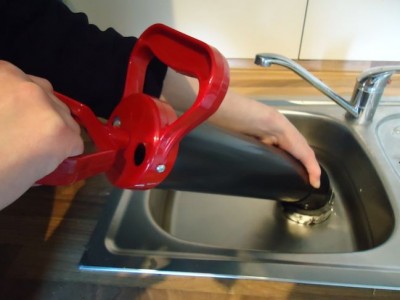 Plombier débouche un évier cuisine avec une pompe à vide