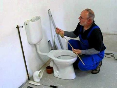 Plombier répare un WC