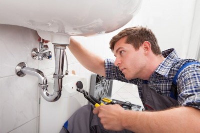 Plombier répare la tuyautrei du lavabo