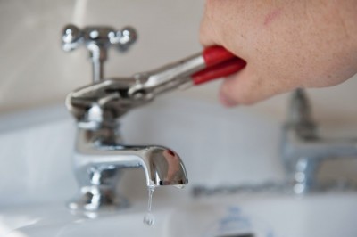 Plombier assure la réparation du robinet qui coule