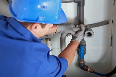 Plombier répare une conduite d'eau