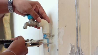 Plombier répare les tuyaux d'un robinet