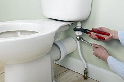 Plombier vérifie les tuyaux du WC après son emplacement
