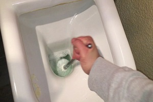 Plombier qui détartre les wc avec de l'acide chlorydrique